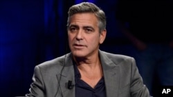 FILE - George Clooney is interviewed on Italy's RAI TV in Milan, Feb. 9, 2014. 