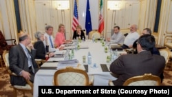 U.S. Secretary of State John Kerry, third from left, and Iranian Foreign Minister Mohammad Javad Zarif, third from right, meet with other officials at an evening session to discuss the nuclear negoatiations in Vienna, Austria, July 11, 2015.