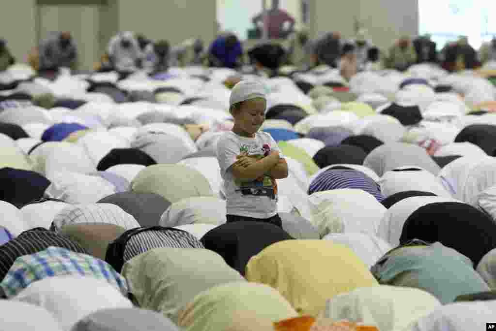 A young boy stands during the Eid al-Fitr prayer marking the end of Islam's holy month of Ramadan, at the Exhibition Center of the Parc Chanot, in Marseille, southern France, July 28, 2014.
