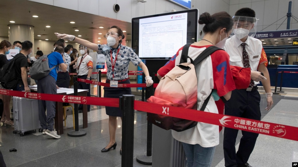 资料照：北京首都机场的工作人员检查旅客们的COVID-19测试结果(photo:VOA)