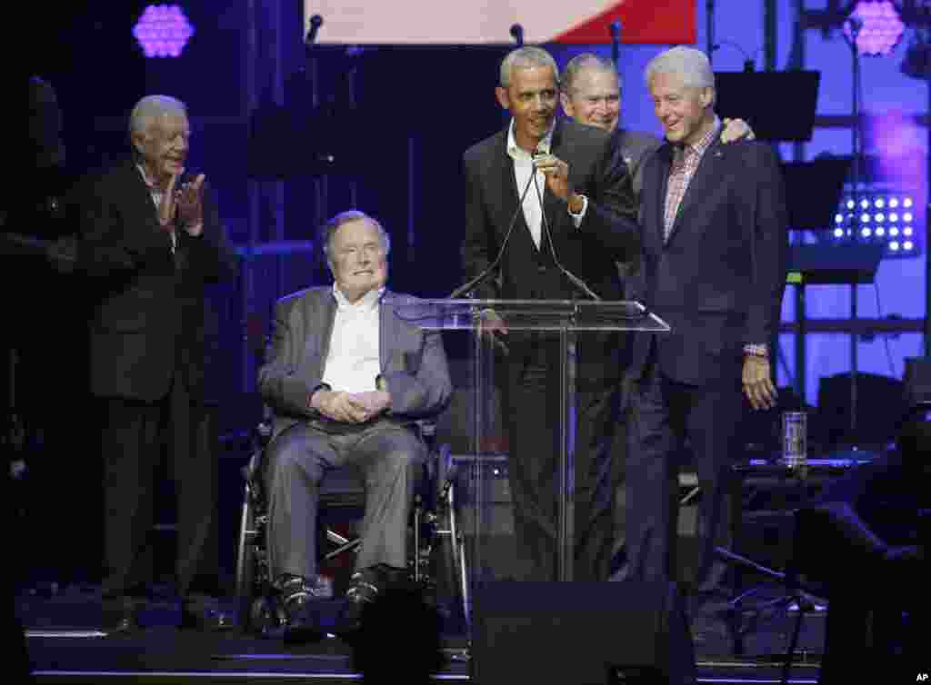 Former President Barack Obama, speaks as fellow former Presidents, from left, Jimmy Carter, George H.W. Bush, George W. Bush, and Bill Clinton look on during a hurricanes relief concert in College Station, Texas, Oct. 21, 2017.