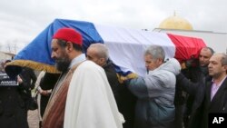 People carry the coffin of slain police officer Ahmed Merabet after a funeral service at the Bobigny Mosque, east of Paris, Jan. 13, 2015. 