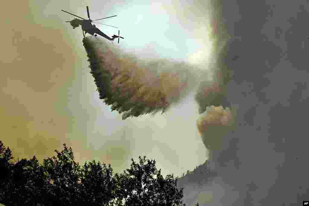 Helikopter menjatuhkan air untuk memadamkan kebakaran di daerah High Park, Colorado.