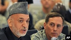 Afghan President Hamid Karzai, left, talks alongside General David Petraeus, U.S. and NATO commander in Afghanistan, at Kabul International Airport (FILE).