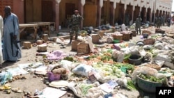 FILE - Soldiers stand guard at a market in N'Djamena following a suicide bomb attack on July 11, 2015. 