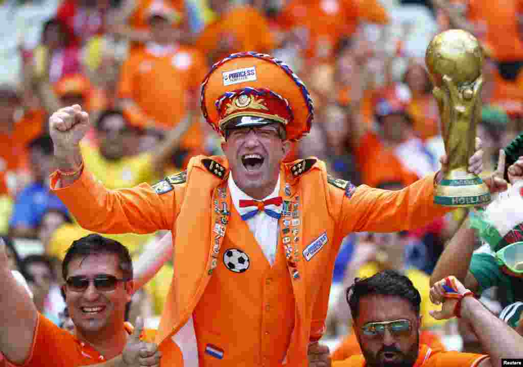 A fan of the Netherlands holding a mock World Cup trophy cheers before the start of the 2014 World Cup round of 16 game between Netherlands and Mexico at Castelao arena in Fortaleza, Brazil.