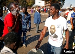 Supporters of the opposition Movement for Democratic Change party douse their faces after teargas was fired during clashes in Harare, Zimbabwe, Aug. 1, 2018.