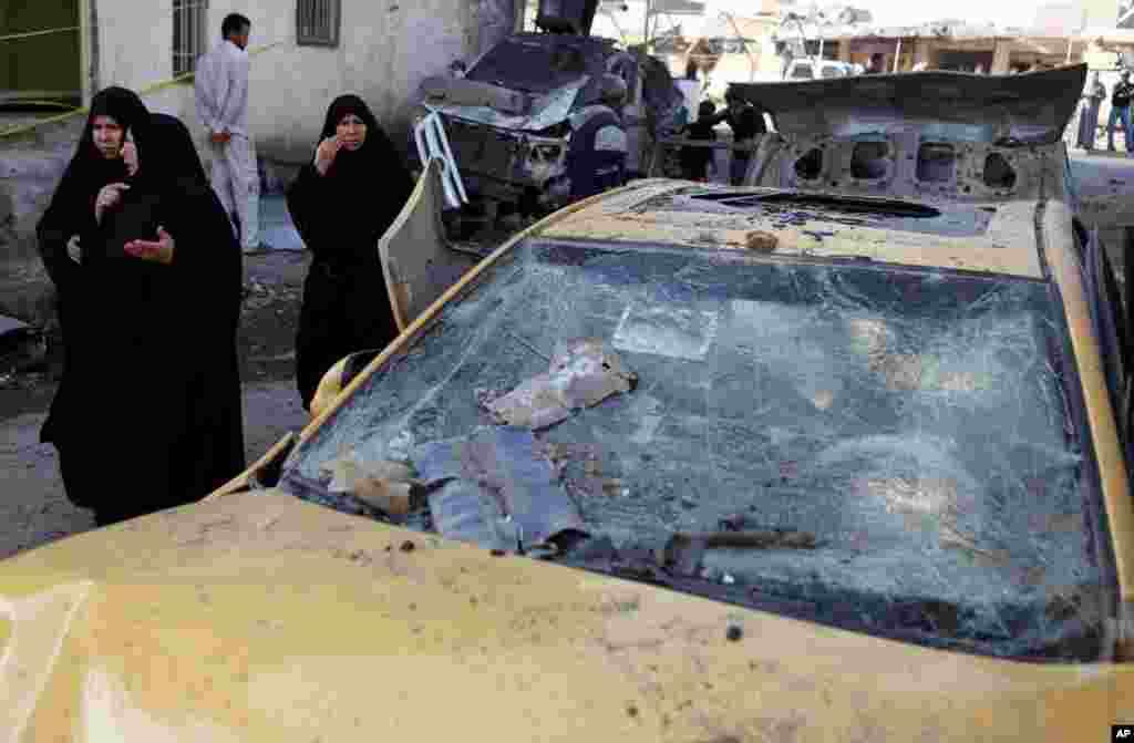 2012年11月29日，一名伊拉克妇女走过爆炸现场。这起炸弹袭击事件发生在伊拉克希拉一处繁忙的商业区。