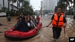 Nhân viên cứu hộ kéo chiếc thuyền cao su đưa cư dân qua một đường phố ngập nước ở Jakarta, ngày 17/1/2013.