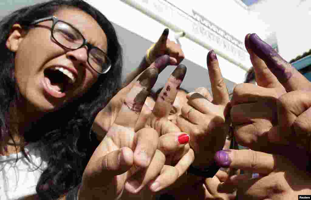 튀니지에서 총선을 실시한 가운데, 투표에 참가한 튀니스 시민들이 잉크가 묻은 손가락을 들어보이고 있다.