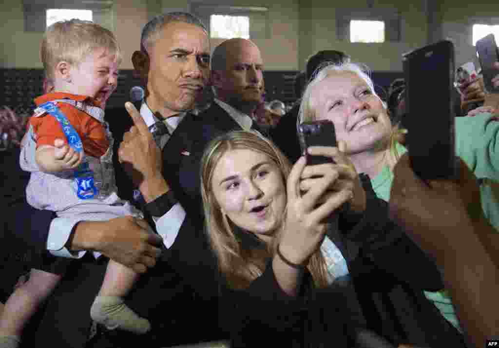 Presiden AS Barack Obama menggendong seorang bayi pada saat ikut berkampanye bagi Capres Partai Demokrat Hillary Clinton di Columbus, Ohio.