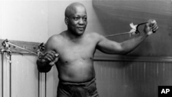 FILE - In this 1932 file photo, boxer Jack Johnson, the first black world heavyweight champion, poses in New York City.
