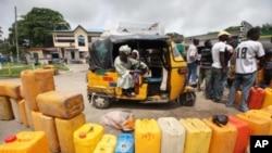 People wait buy kerosene at a petrol station in Lagos, Nigeria, July 4, 2011.