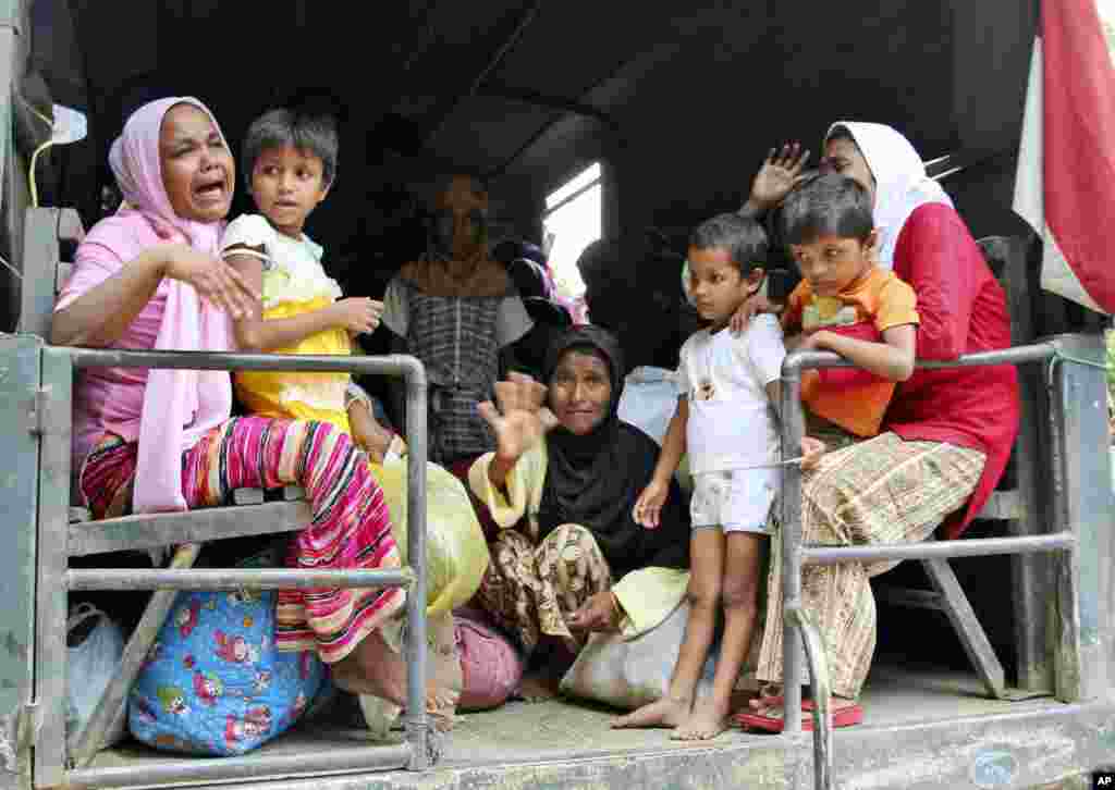 Ethnic Rohingya women and children whose boats were washed ashore on Sumatra Island board a military truck to be taken to a temporary shelter in Seunuddon, Aceh province, Indonesia.