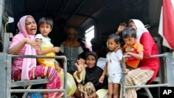 Ethnic Rohingya women and children whose boats were washed ashore on Sumatra Island board a military truck to be taken to a temporary shelter in Seunuddon, Aceh province, Indonesia, Sunday, May 10, 2015. 