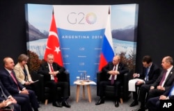 Russian President Vladimir Putin, center right, and Turkey's President Recep Tayyip Erdogan, center left, attend the talks at the G20 summit in Buenos Aires, Argentina, Dec. 1, 2018.