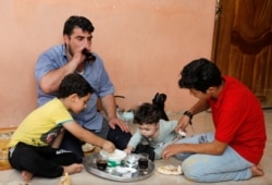 Mohammed Sattar makan bersama anak-anaknya di rumah di Mosul, Irak, 1 September 2020. (Foto: REUTERS/ Khalid al-Mousily)