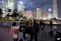 Stargazers use telescopes to observe the moon along the Victoria Habour in Hong Kong, Jan. 31, 2018.