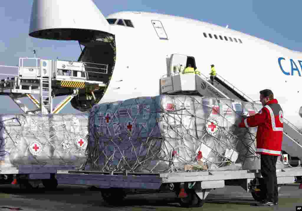 Seorang pekerja Palang Merah Jerman memasukkan donasi untuk para penyintas Topan Haiyan ke pesawat di Bandar Udara Schoenefeld di Berlin, Jerman (13/11). (AP/Michael Sohn)