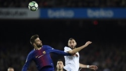 Le défenseur espagnol de Barcelone Gerard Pique (L) prend la tête de l'attaquant français du Real Madrid Karim Benzema lors du match de football entre le FC Barcelona et le Real Madrid CF au stade Camp Nou de Barcelone le 6 mai 2018.