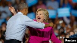 FILE - President Barack Obama and Democratic presidential candidate Hillary Clinton embrace during a campaign rally in Charlotte, North Carolina, July 5, 2016.
