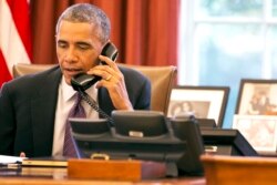 El presidente Barack Obama habla por teléfono sobre el Ebola el 8 de octubre de 2014, en la Oficina Oval de la Casa Blanca en Washington.