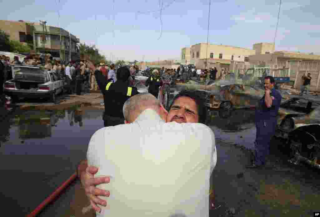 Thân nhân an ủi nhau tại hiện trường, nơi có xe bom nổ ở thủ đô Baghdad.