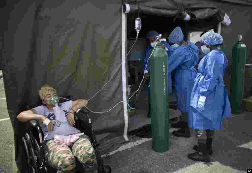 A woman who suffers from COVID-19, receives oxygen at a field hospital set up in the parking lot of the Poliedro de Caracas auditorium, in Venezuela, March 21, 2021.