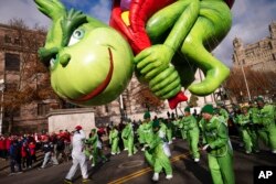 FILE - If you are a "Grinch," you are not in the holiday spirit. Here, a balloon of Dr. Seuss' The Grinch steals presents from children in the Macy's Thanksgiving Day Parade, Nov. 28, 2019, in New York. (AP Photo/Mark Lennihan)