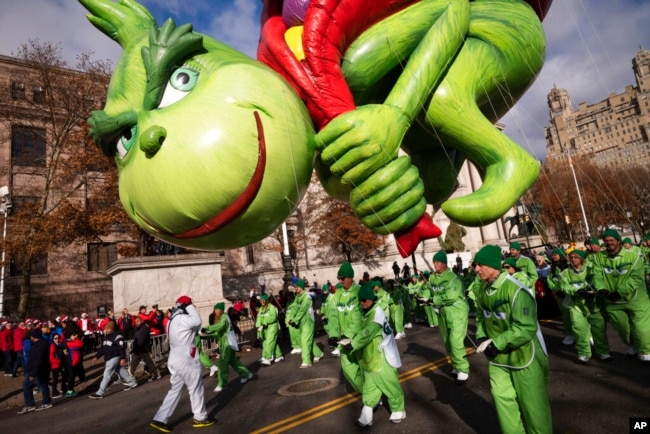 FILE - If you are a "Grinch," you are not in the holiday spirit. Here, a balloon of Dr. Seuss' The Grinch steals presents from children in the Macy's Thanksgiving Day Parade, Nov. 28, 2019, in New York. (AP Photo/Mark Lennihan)