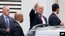 Republican presidential candidate Donald Trump waves as he arrives for a meeting with House Speaker Paul Ryan