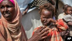 Nasteho Hassan Mohyadin, 3, and her mother Farhid Ali Mohamed sit outside their small makeshift tent in a camp for those displaced by 2012 famine or by conflict, in Mogadishu, Somalia.