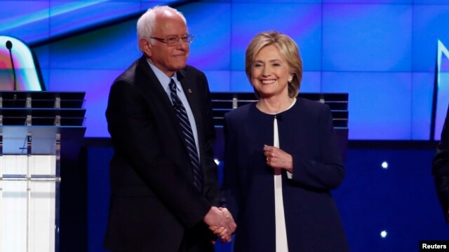 U.S. Senator Bernie Sanders greets former Secretary of State Hillary Clinton as he arrives onstage for the first official Democratic candidates debate of the 2016 presidential campaign in Las Vegas, Nevada, Oct. 13, 2015.