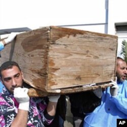 Men carry a coffin at Al-Jalaa hospital in Benghazi on Feb 2011