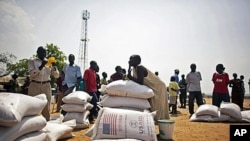 Southern Sudanese who recently returned from northern Sudan receive food rations from the World Food Program in the southern capital of Juba, 07 Jan 2011