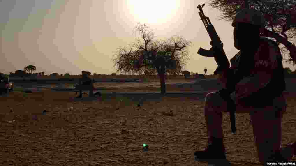 Un soldat de la garde nationale nigérienne surveille l'horizon dans le village de Zenam Kelouri, le 29 février 2016. (VOA/Nicolas Pinault)