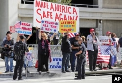 FILE - Police stand by as demonstrators who support President Donald Trump's executive order barring entry to the U.S. by travelers from seven Muslim-majority countries demonstrate across the street from the Tom Bradley International Terminal at Los Angeles International Airport, Feb. 4, 2017.