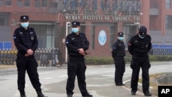 2021年2月3日星期三世界衛生組織小組在中國湖北省武漢市訪問期間保安人員聚集在武漢病毒研究所入口附近。