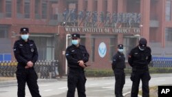 Security personnel gather near the entrance of the Wuhan Institute of Virology during a visit by the World Health Organization team in Wuhan in China's Hubei province on Wednesday, Feb. 3, 2021. 