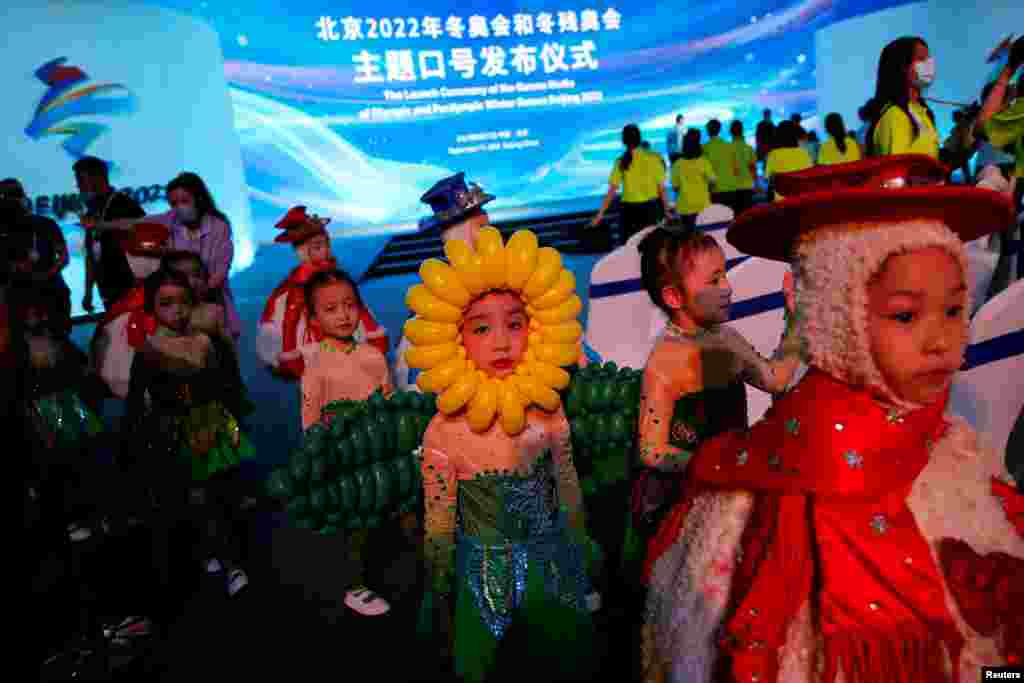 Young performers dressed in costumes leave after a ceremony unveiling the slogan for the Beijing 2022 Winter Olympic Games, in Beijing, China.