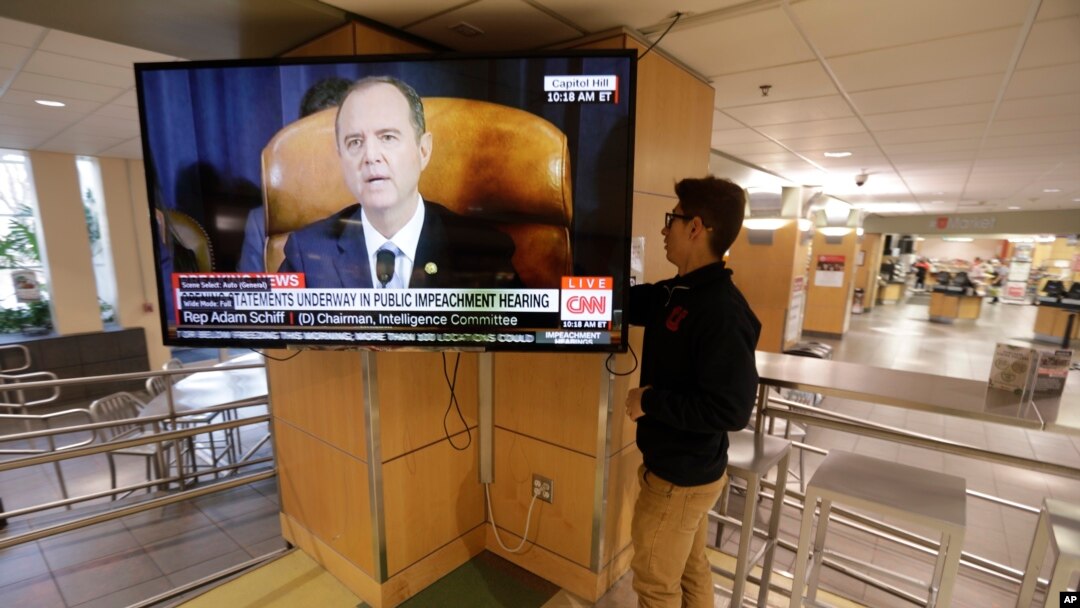 Mahasiswa Universitas Utah, Suyog Shrestha, menyaksikan Ketua Komite Intilijen DPR AS Adam Schiff memberikan sambutan dalam sidang dengar pendapat penyelidikan pemakzulan Presiden Donald Trump, di Salt Lake City, Utah, 13 November 2019.