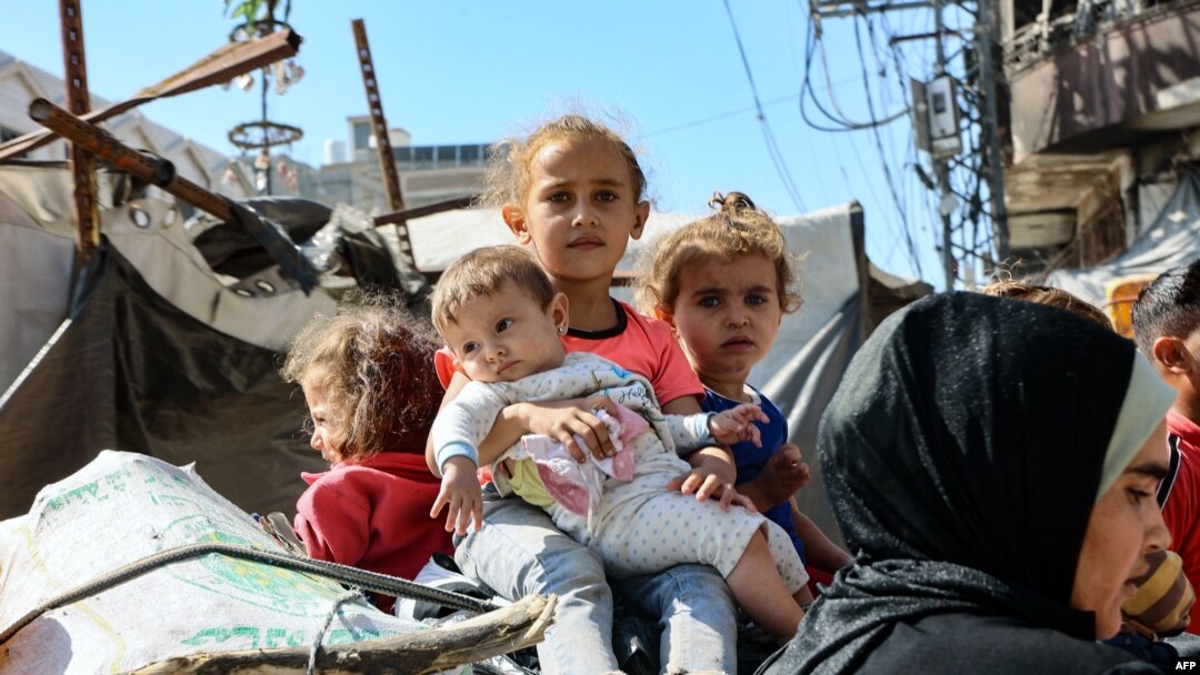 Niños palestinos se sientan encima de las pertenencias de su familia mientras huyen de las zonas al norte de la ciudad de Gaza, en el norte de la Franja de Gaza, el 12 de octubre de 2024.