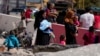 People carry their luggage as they cross into Syria on foot, through a crater caused by Israeli airstrikes aiming to block Beirut-Damascus highway at the Masnaa crossing, in the eastern Bekaa Valley, Lebanon, Oct. 5, 2024.