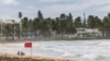 Turistas captados en playa La Pared mientras la tormenta tropical Ernesto pasa por Luquillo, Puerto Rico, el martes 13 de agosto de 2024.