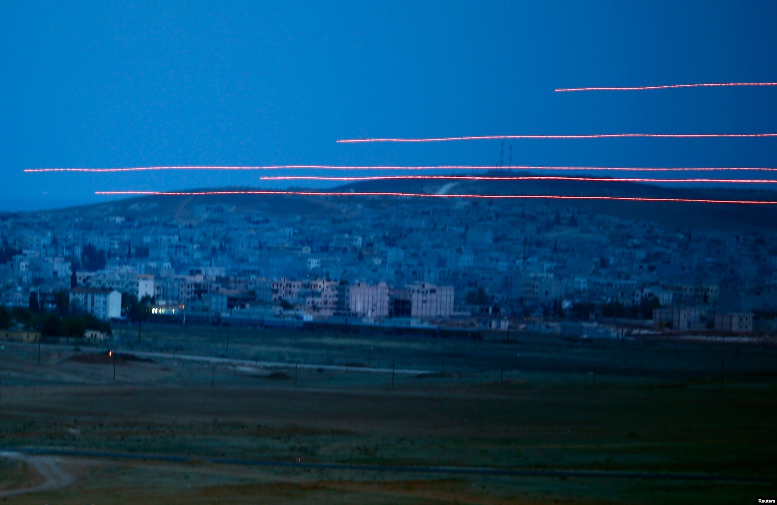Tracer rounds cross the sky over the Syrian town of Kobani, as seen from the Mursitpinar crossing on the Turkish-Syrian border in the southeastern town of Suruc in Sanliurfa province.