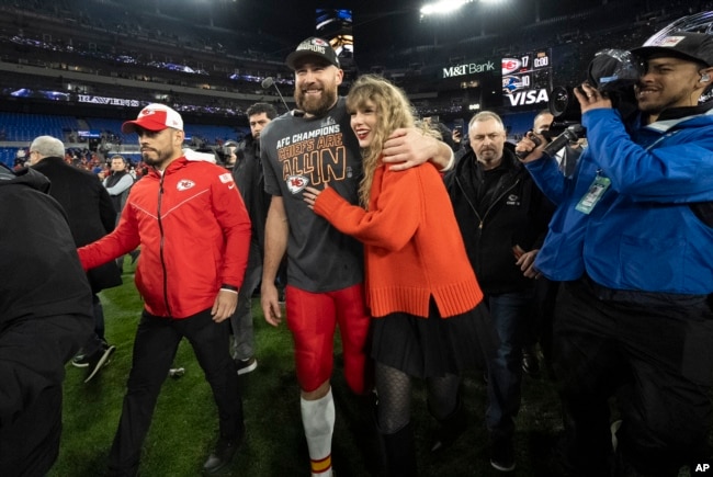 FILE - Kansas City Chiefs tight end Travis Kelce walks with Taylor Swift following the AFC Championship NFL football game between the Baltimore Ravens and the Kansas City Chiefs in Baltimore on Jan. 28, 2024. (AP Photo/Julio Cortez, File)