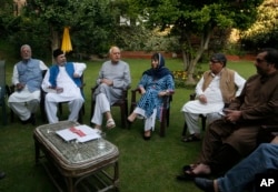 Former Jammu and Kashmir Chief Minister Mehbooba Mufti, fourth left, National Conference president Farooq Abdullah, third left and other leaders sit during an all parties meeting in Srinagar, Aug. 4, 2019.