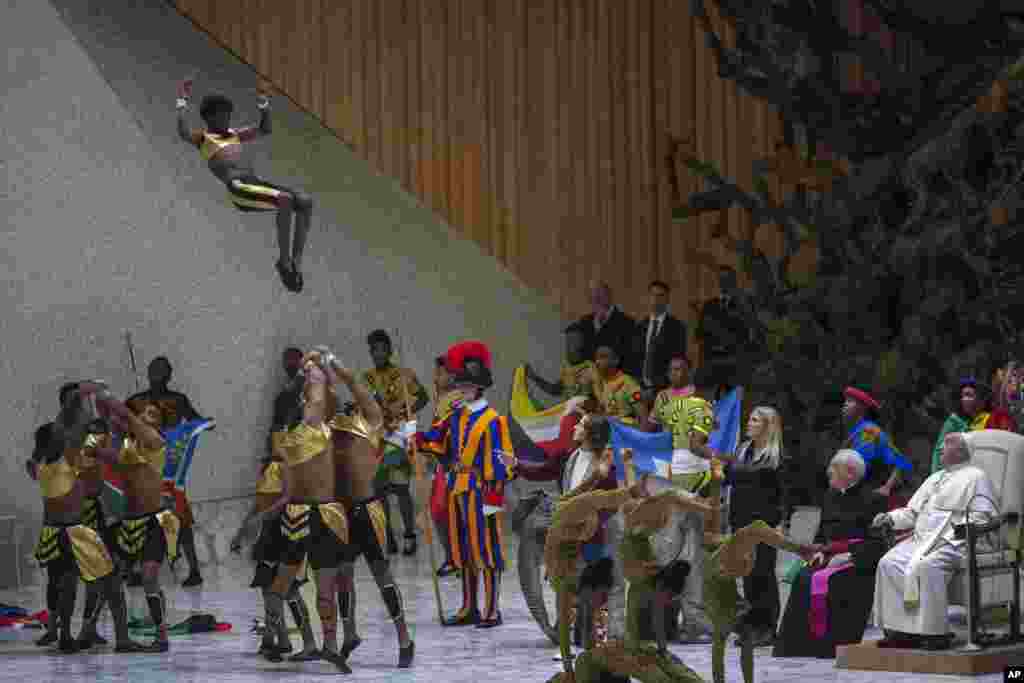 Pope Francis, right, looks at a performance by CircAfrica circus troupe during the weekly general audience in the Paul VI Hall, at the Vatican. (AP Photo/Alessandra Tarantino)