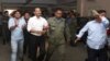 FILE - Meach Sovannara, center left, of the Cambodia National Rescue Party (CNRP) and a CNRP supporter, left, are escorted by police at a Phnom Penh court after 11 CNRP members were sentenced in connection with the Freedom Park protests, July 21, 2015. 