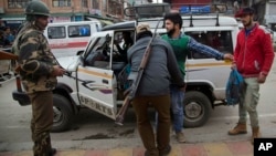 In this Nov. 4, 2015 file photo, a security officer frisks a Kashmiri at a temporary checkpoint in Srinagar, Indian controlled Kashmir. 